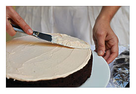 Good Amount Of Frosting On Top Of The First Cake. Using A Spatula